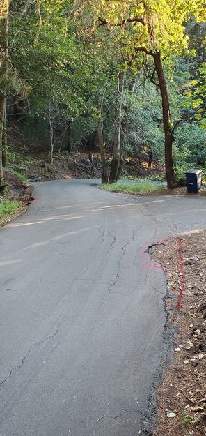 Cars cut the corner driving over this dirt area when passing, using Manfredi driveway as a turnout?